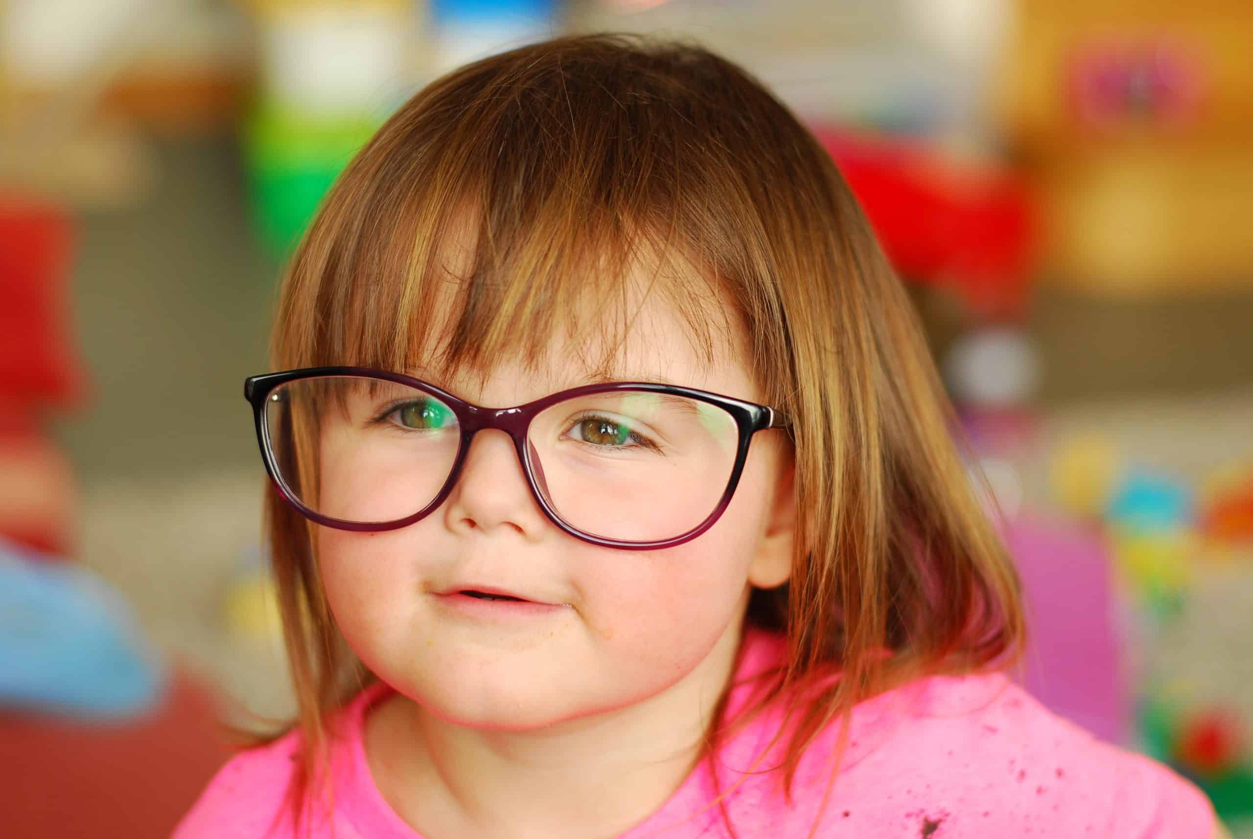Image of girl in pink t-shirt wearing over-sized glasses